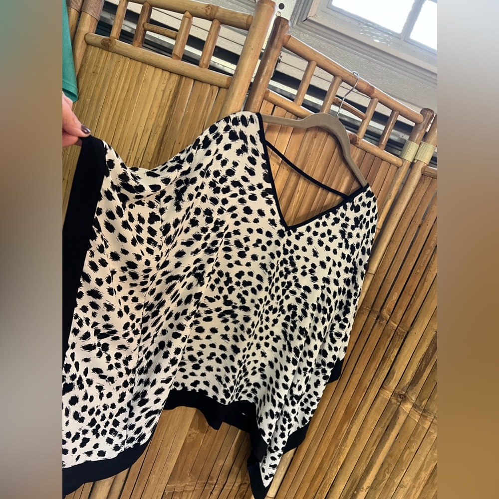 A beyer/ medium/ flowy black white animal print/ opens on arms. Poly fabric